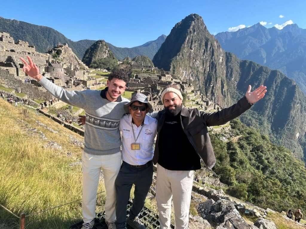 Happy tourists enjoying the best time to visit Machu Picchu with clear blue sky